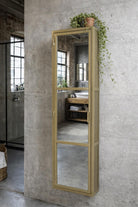 Industrial Mirrored Tall Slim Bathroom Cabinet - Antique Brass on a concrete wall in an industrial style bathroom